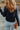 a woman with long hair wearing a black sweater and blue jeans