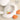 a white baby rattle with orange and blue balls