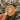 a hand holding a round brown coaster