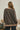 a woman standing in front of a white wall