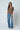 a woman in a brown sweater and blue jeans