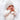 a baby in a white outfit and hat holding a cookie