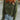 a woman wearing a green sweater and blue jeans
