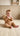 a baby sitting on the floor holding a toy