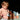 a baby sitting on a blanket with a bottle of lotion