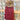 a red knit hat with a brown pom on a wooden fence